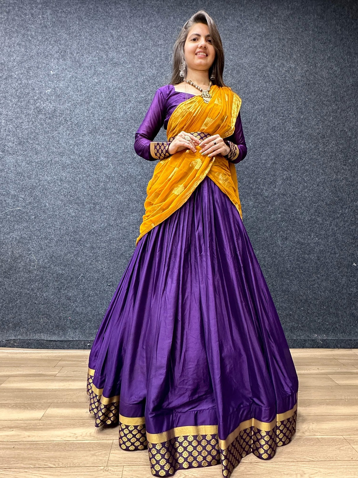 Photo of Ombre shimmery mango yellow and purple lehenga with bride sitting  on chair